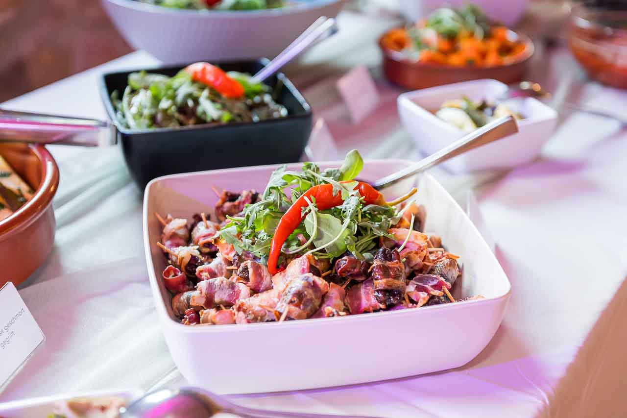 Kulinarische Köstlichkeiten in Mosterei Ockensen: Datteln im Speckmantel, raffiniert angerichtet mit frischen Kräutern und Chili. Ein Fest für die Sinne.