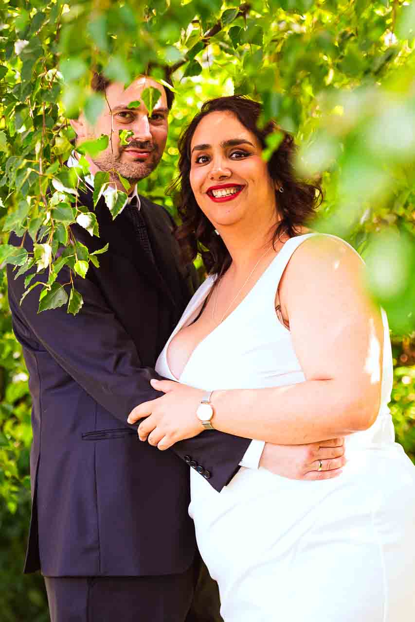 Brautpaar-Foto in Mosterei Ockensen: Die strahlende Braut im weißen Kleid, liebevoll vom Bräutigam umarmt, ein unvergesslicher Moment.