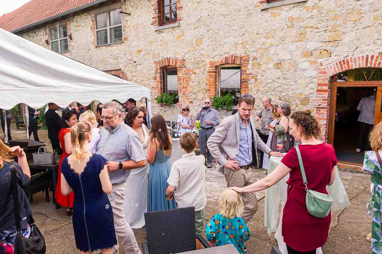 Festliche Gesellschaft feiert in der Mosterei Ockensen. Elegante Kleider, entspannte Atmosphäre und stilvolle Details. Ein unvergesslicher Tag!