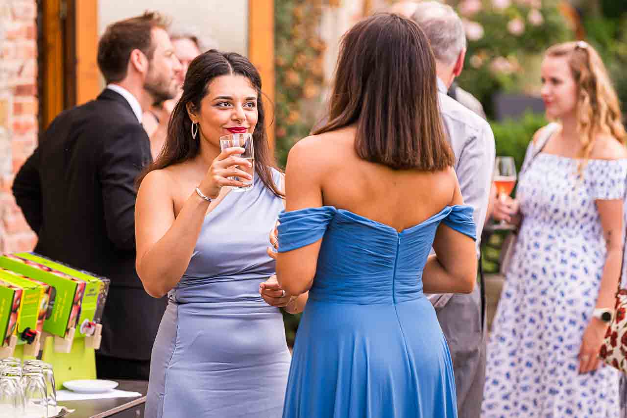 Elegante Hochzeitsgäste in stilvollen Kleidern in Mosterei Ockensen. Festliche Atmosphäre, ansprechende Mode für die weibliche Zielgruppe.