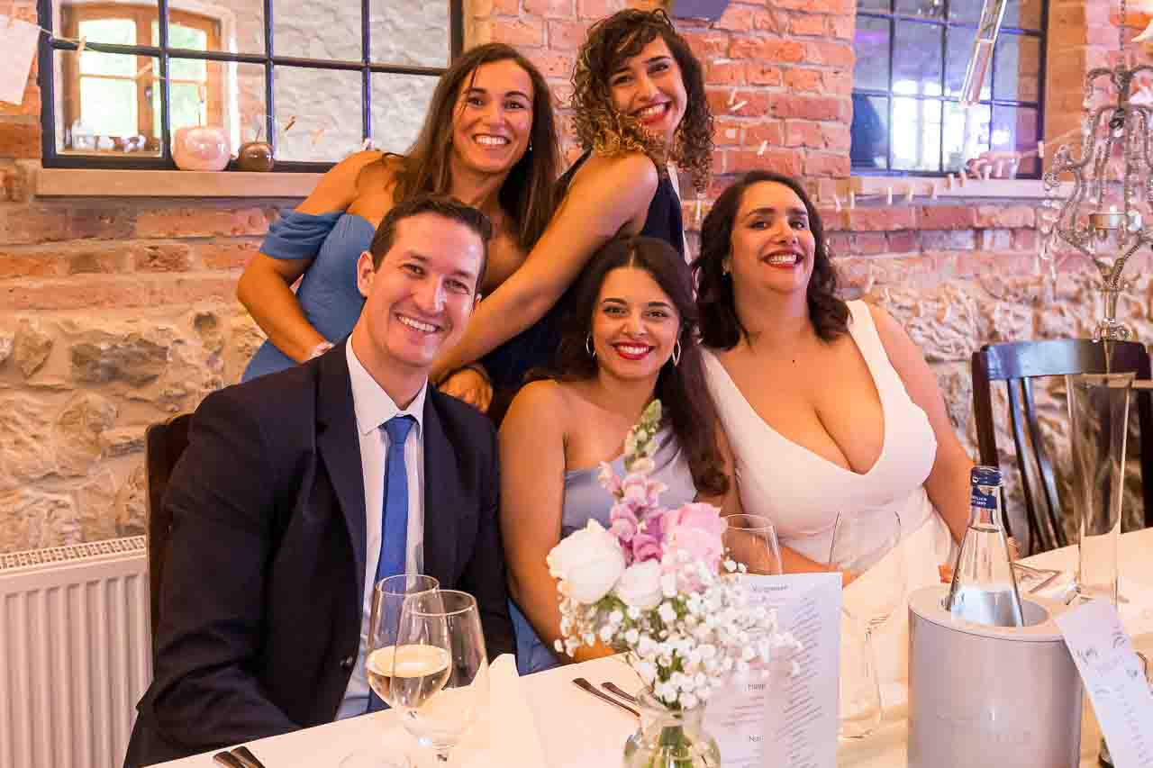 Festliche Damenrunde in stilvoller Location. Elegante Kleider, strahlende Gesichter und blumige Tischdeko für besondere Momente.