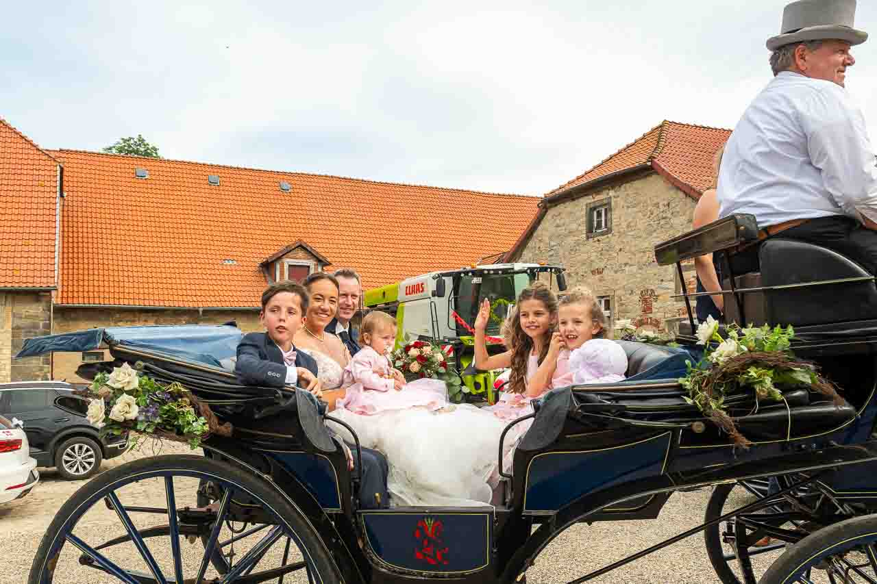 Hochzeitsgesellschaft in festlicher Kutsche. Die Braut strahlt, umgeben von ihren Liebsten. Ein unvergesslicher Tag voller Liebe und Freude.