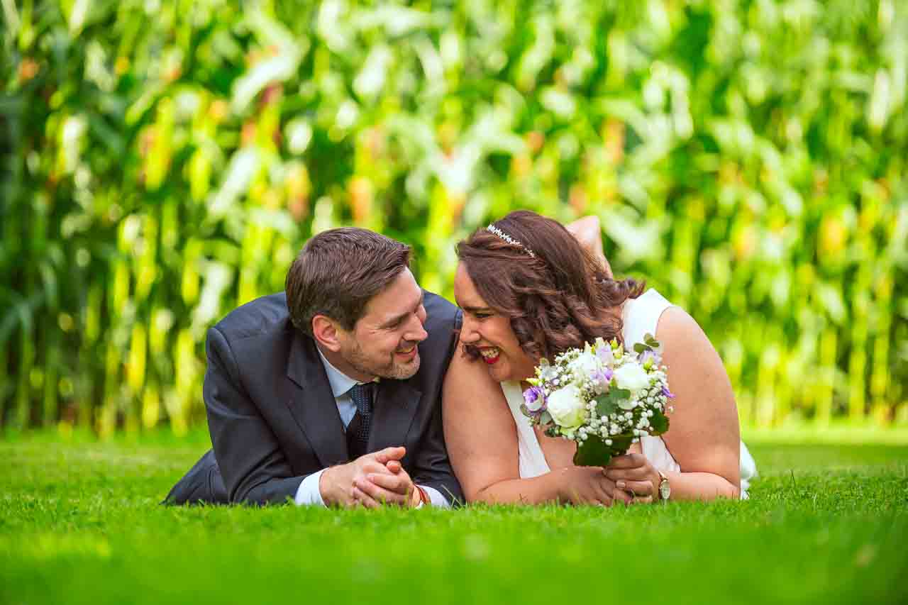 Romantische Hochzeit in Hildesheim: Brautpaar liegt glücklich im Grünen, Braut mit Blumenstrauß, inniger Moment, liebevolle Erinnerung