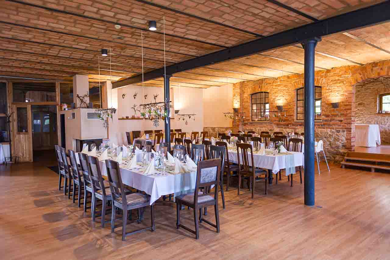 Festlich gedeckte Tische in der Mosterei Ockensen. Rustikales Ambiente für besondere Anlässe. Perfekt für Hochzeiten und Feiern.