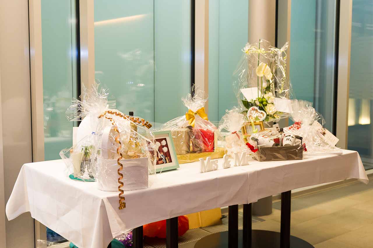 Festlich dekorierter Tisch mit liebevoll verpackten Hochzeitsgeschenken, darunter Blumen, Praesente und die Aufschrift "Mrs & Mr", perfekt fuer das Brautpaar.