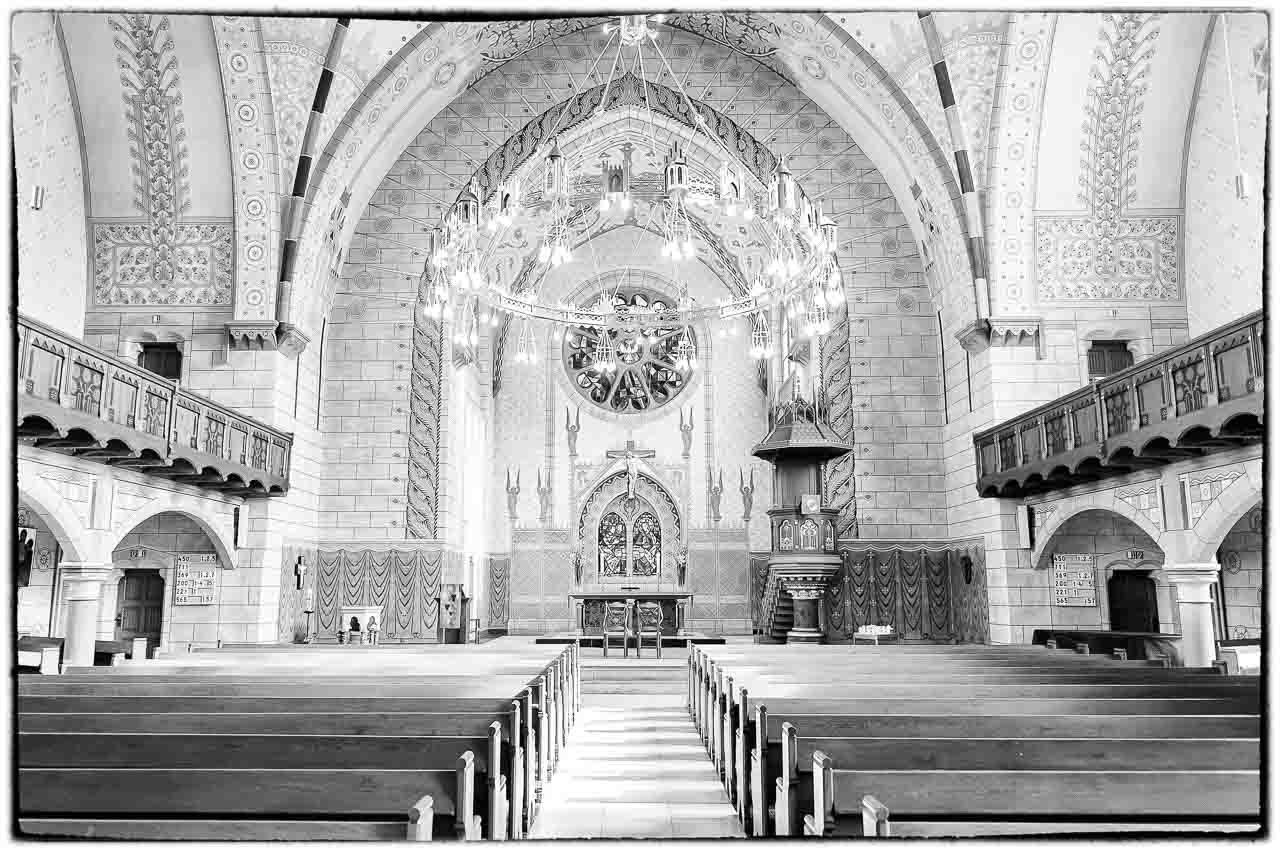 Eindrucksvolle Innenaufnahme einer Kirche mit kunstvollen Verzierungen. Der Blick faellt auf den Altarraum. Ein schoener Ort fuer Trauungen in der Kirche.
