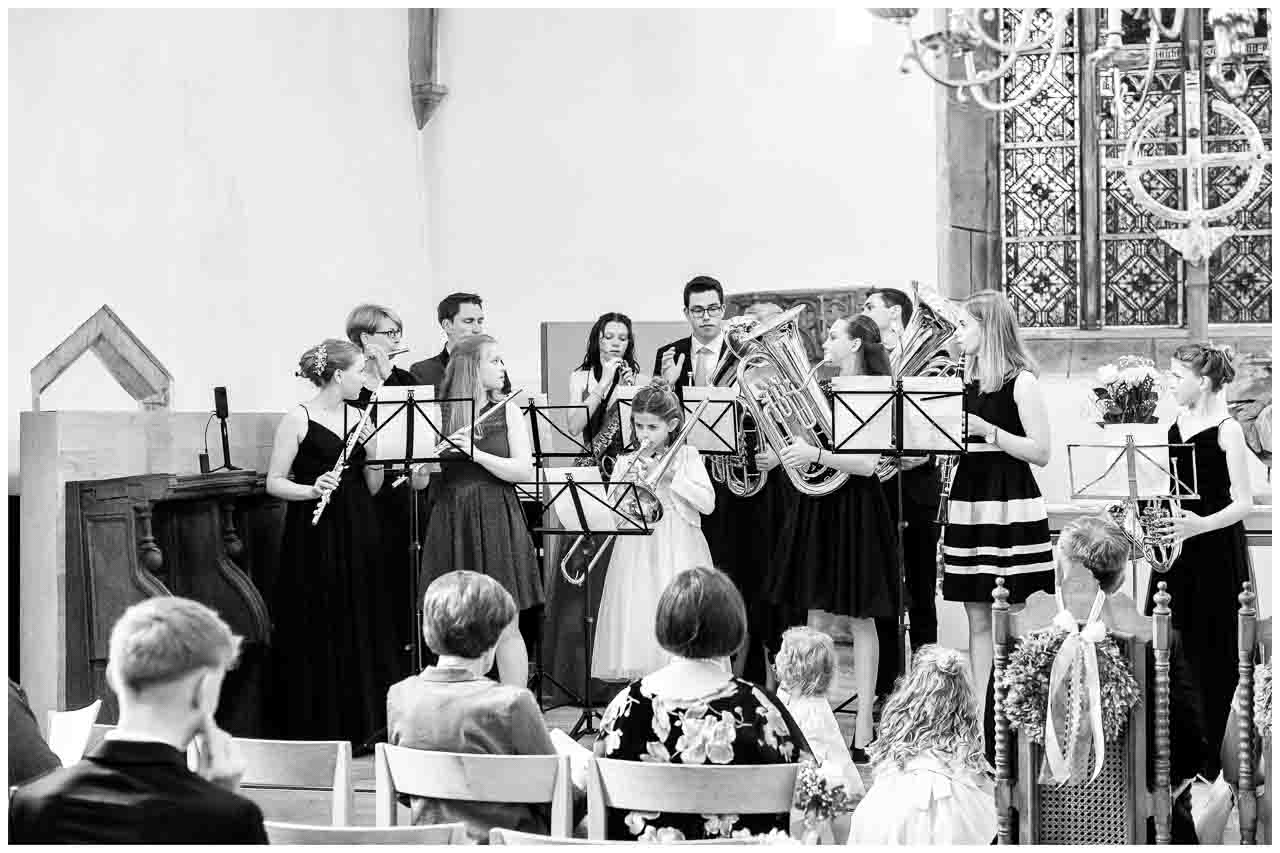 In der Kirche: Jugendliches Orchester spielt zur Feier, elegante Kleider und festliche Musik erfuellen den Raum mit Harmonie und Freude.