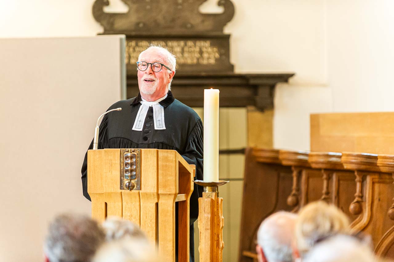 In der Kirche: Ein Pfarrer hält eine bewegende Predigt, begleitet von einer Kerze. Ein Moment der Besinnung und Inspiration.