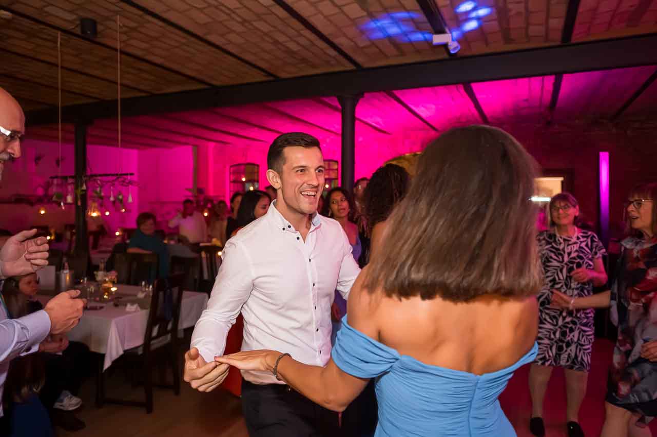 Tanzende Menschen in Hannover genießen die ausgelassene Stimmung. Elegante Kleider, fröhliche Gesichter und festliche Beleuchtung.