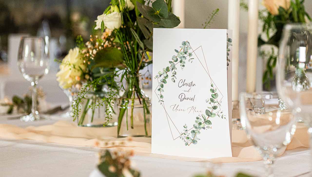 Elegante Tischdeko mit zarten Blumen, Eukalyptus und edler Menuekarte fuer die Hochzeit. Romantische Details fuer den schoensten Tag.