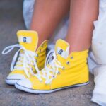 Gelbe Sneaker mit weissen Schnuersenkeln, die einen Hauch von Farbe in jedes Outfit bringen. Ideal fuer einen laessigen, aber stilvollen Look.